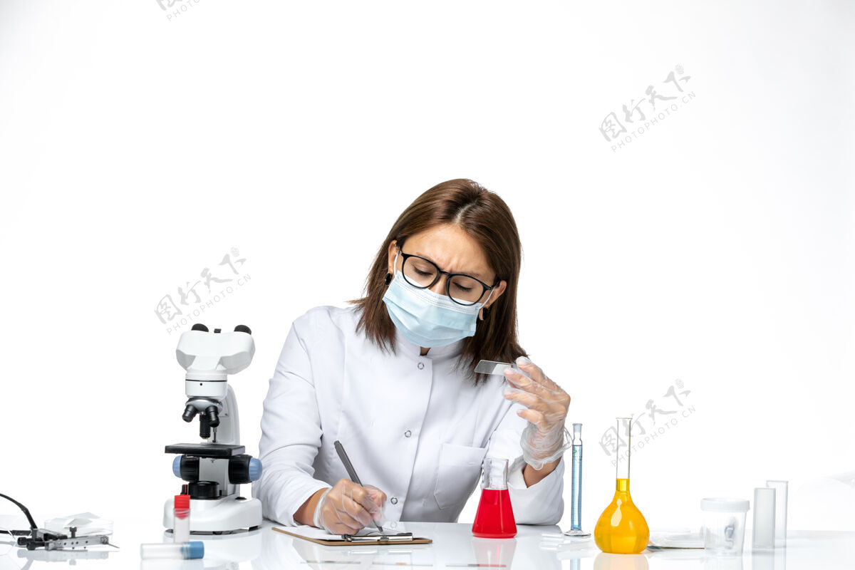 医生前视图：女医生穿着白色医疗服 戴着面罩 因为白色空间上有covid字样书写医疗正面