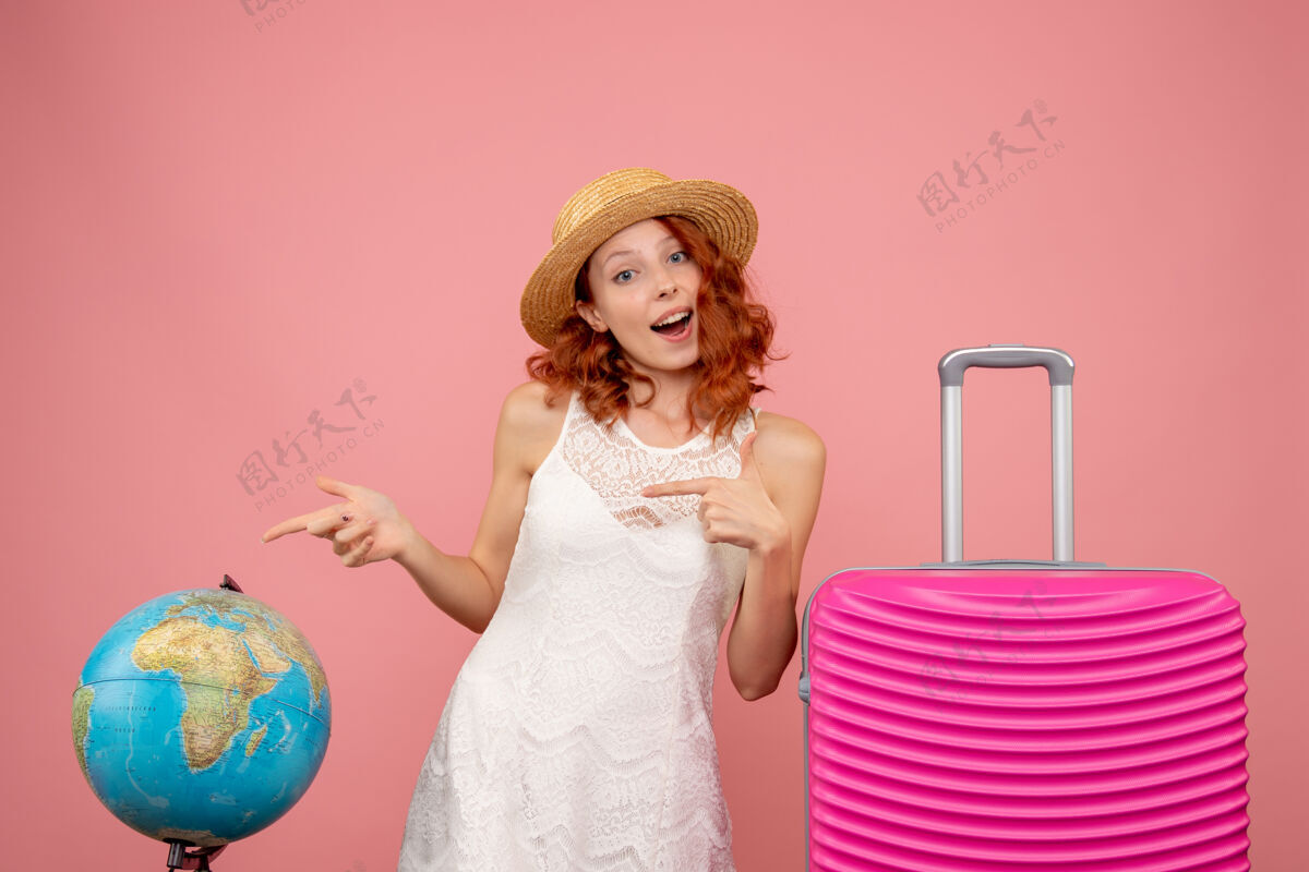 衣服年轻女性游客的正面图 粉红色的墙上挂着粉红色的包时尚航行可爱