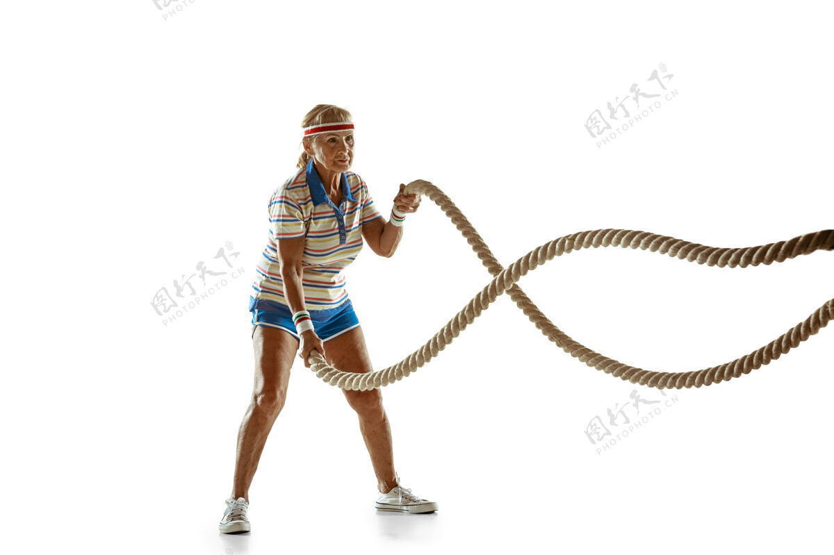 运动高级女子训练与绳子在白色背景的运动装球设备运动