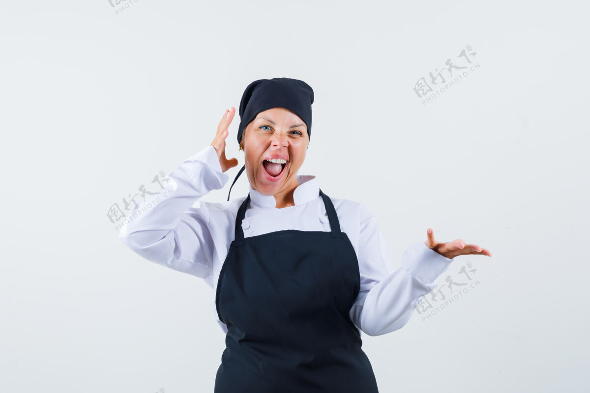 正面女厨师假装拿着什么东西 穿着制服 围着围裙 看上去很开心 正面照卷发女性欢呼