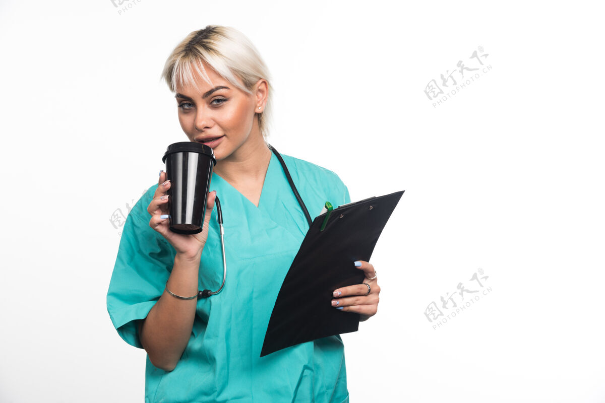 成人女医生在白色表面喝咖啡制服女性女士