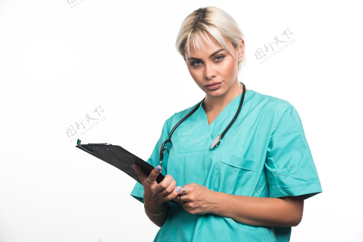 女士女医生用听诊器把剪贴板放在白色的表面上医生女性拿着