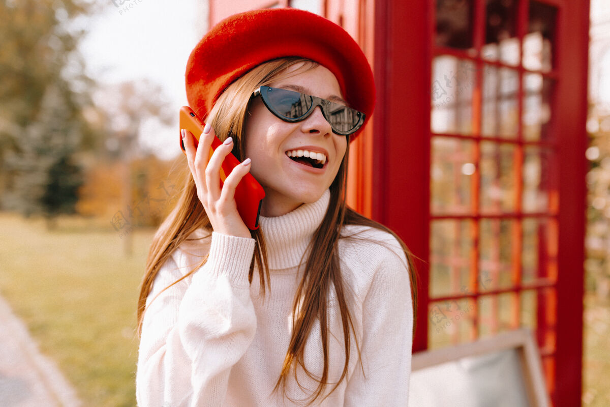 流动穿着红色贝雷帽在街上打电话的女人自信红色自由
