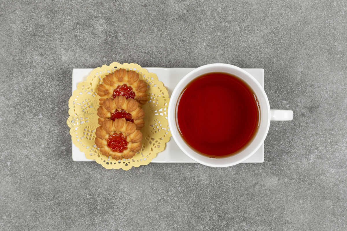 饼干自制饼干加果冻和一杯茶放在白碟子上美味杯子饼干