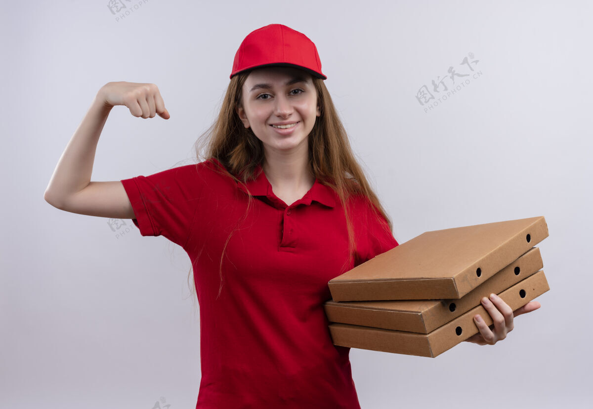 年轻微笑着的年轻送货女孩 穿着红色制服 手里拿着披萨包 在孤零零的白墙上做着强烈的手势抱着制服披萨
