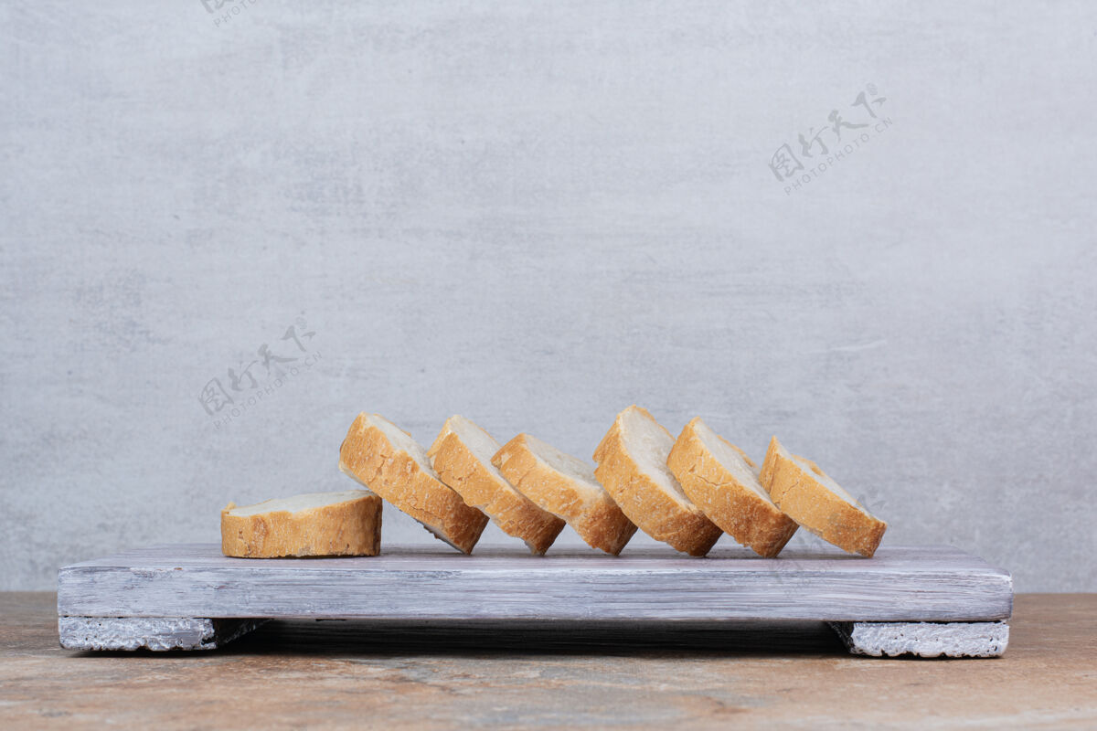 一半把面包片放在木板上新鲜法式面包好吃的