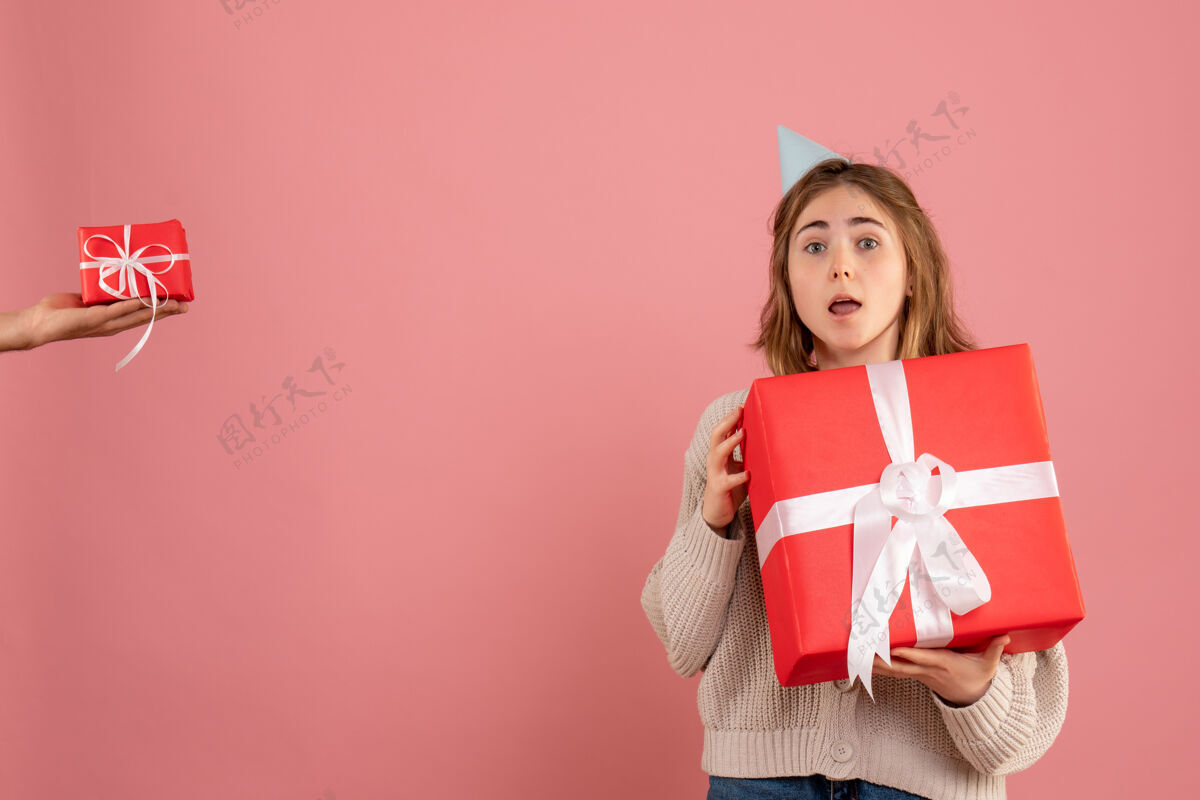 手持年轻的女性拿着圣诞礼物 接受粉色的男性礼物男士礼物圣诞节