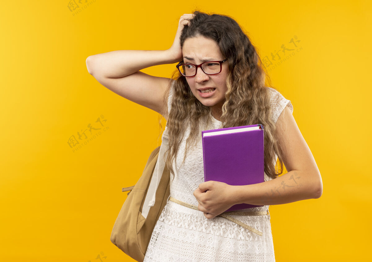 背部迷茫的年轻漂亮的女学生戴着眼镜背着书包望着边上隔离着黄色的复印空间困惑漂亮女学生