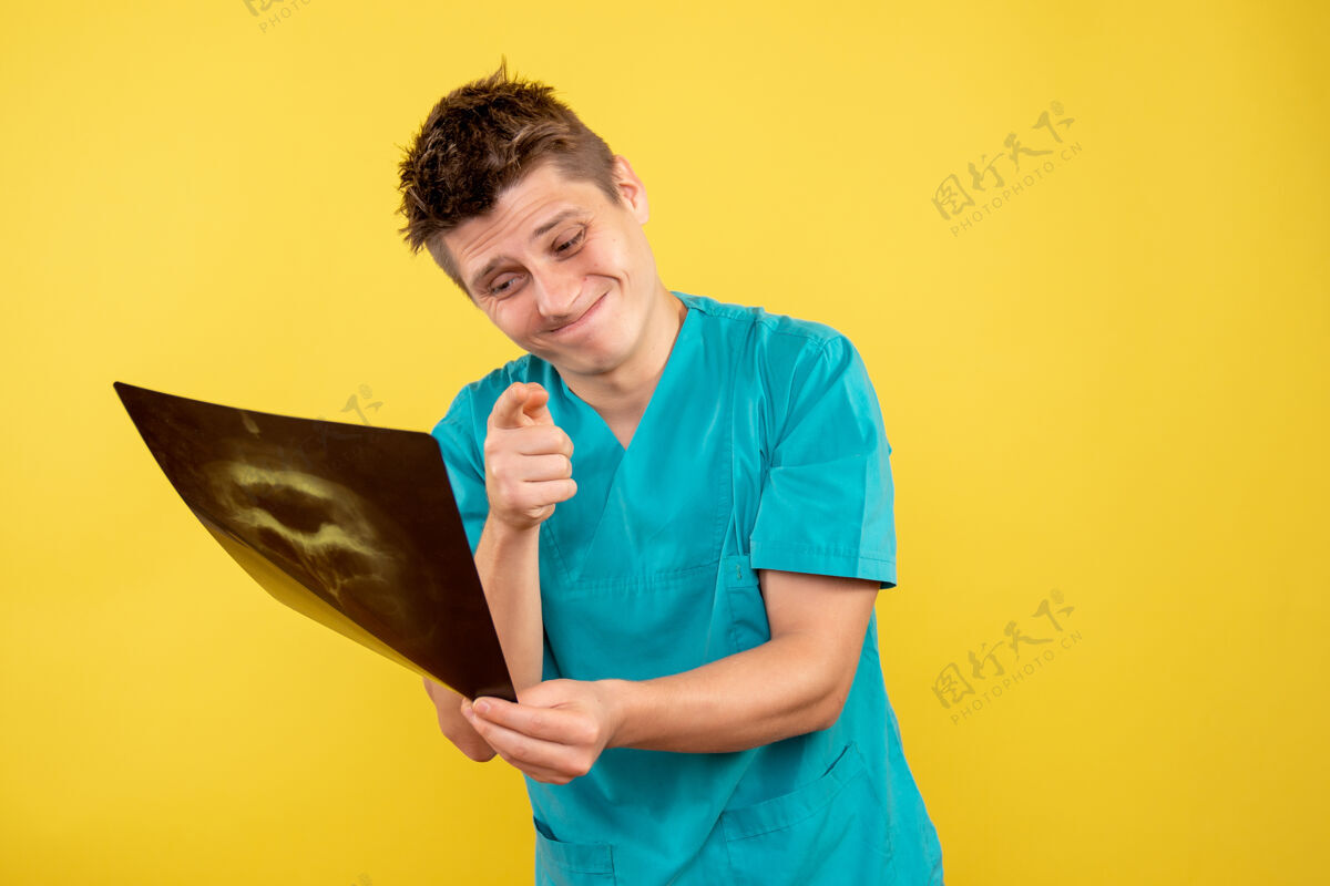 西装正面图身穿医疗服的年轻男医生拿着黄色的x光片肖像病毒医疗
