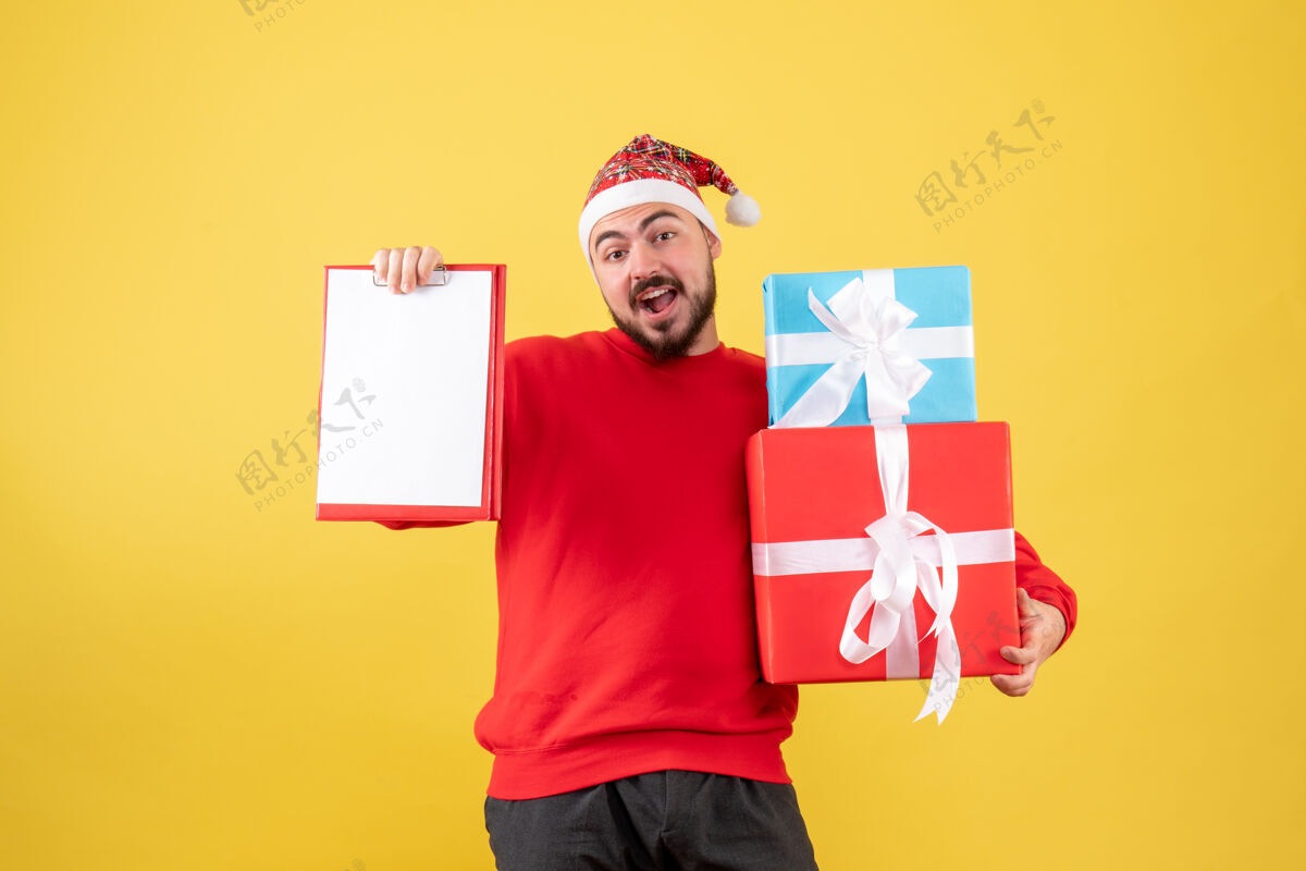 便条前视图年轻男性与圣诞礼物和黄色背景上的注意人男人年