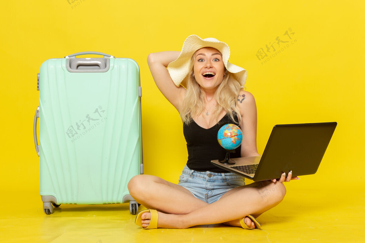 视图前视图年轻女性拿着她的笔记本电脑和地球仪快乐旅程女性
