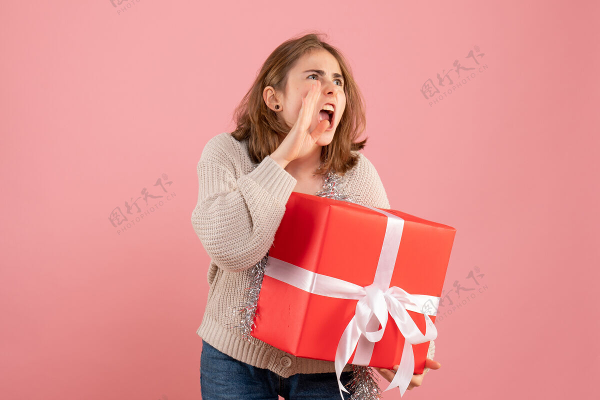 购物手拿圣诞礼物的年轻女性粉红购物者礼物手