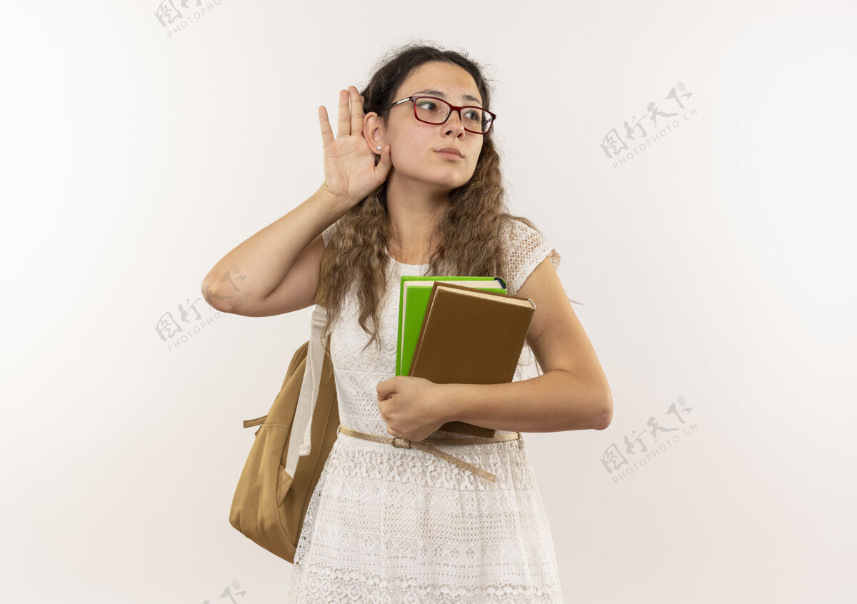 复制好奇的年轻漂亮女学生戴着眼镜背着书包做着听不见你的手势看着白色的边上孤立着的复印空间女学生眼镜包