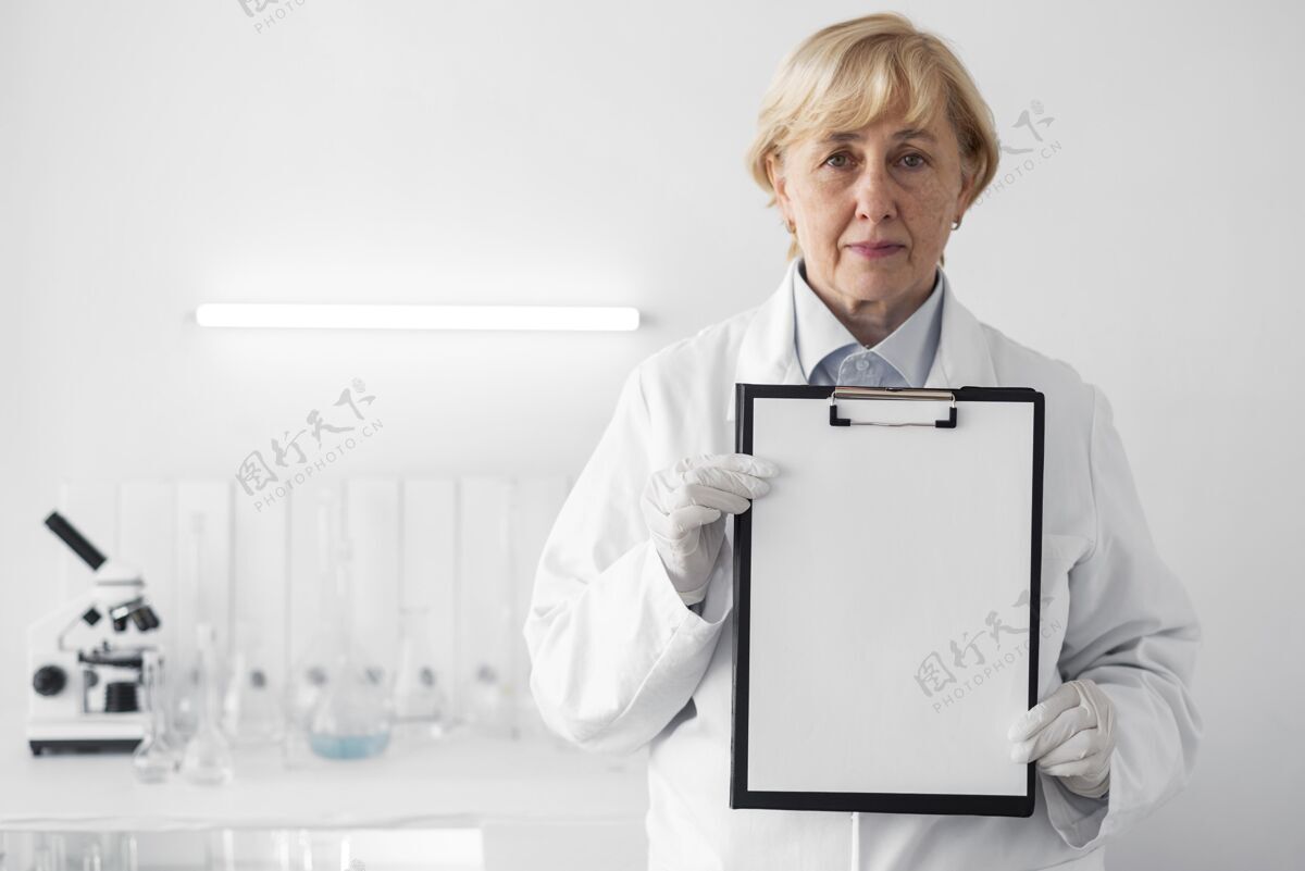 实验室实验室里的女人在展示剪贴板手套测试女人