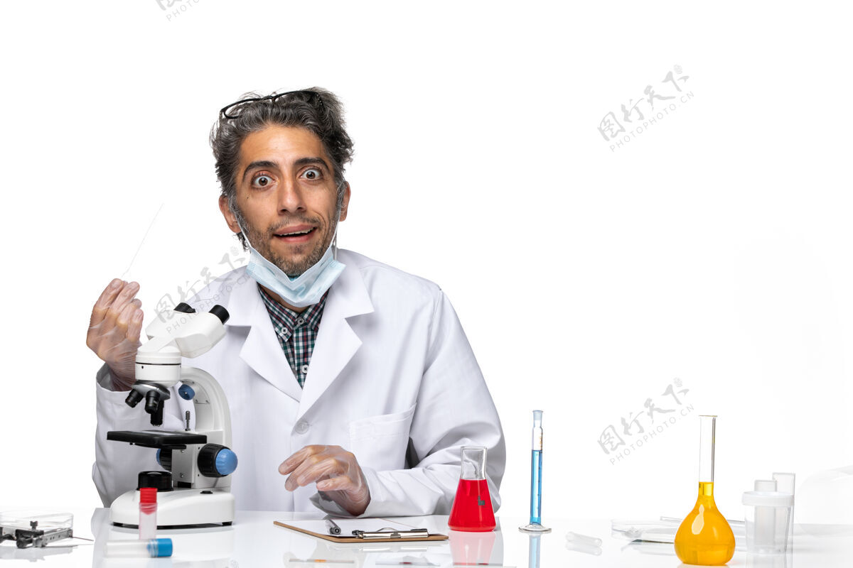 科学穿着白色医疗服的中年科学家使用显微镜的正视图科学医学实验室