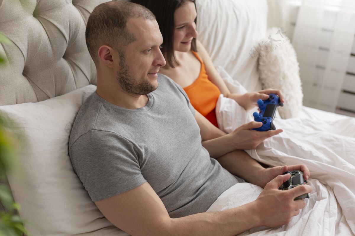 水平夫妻俩在床上玩电子游戏乐趣在线娱乐