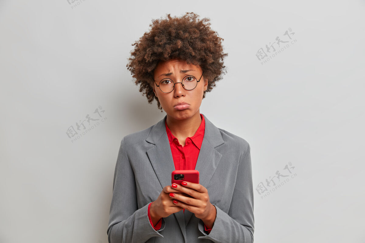 发短信伤心失望的女经理或行政助理在工作中有问题 使用手机 等待重要电话 无法解决困难的情况 站在室内技术女人女商人工作