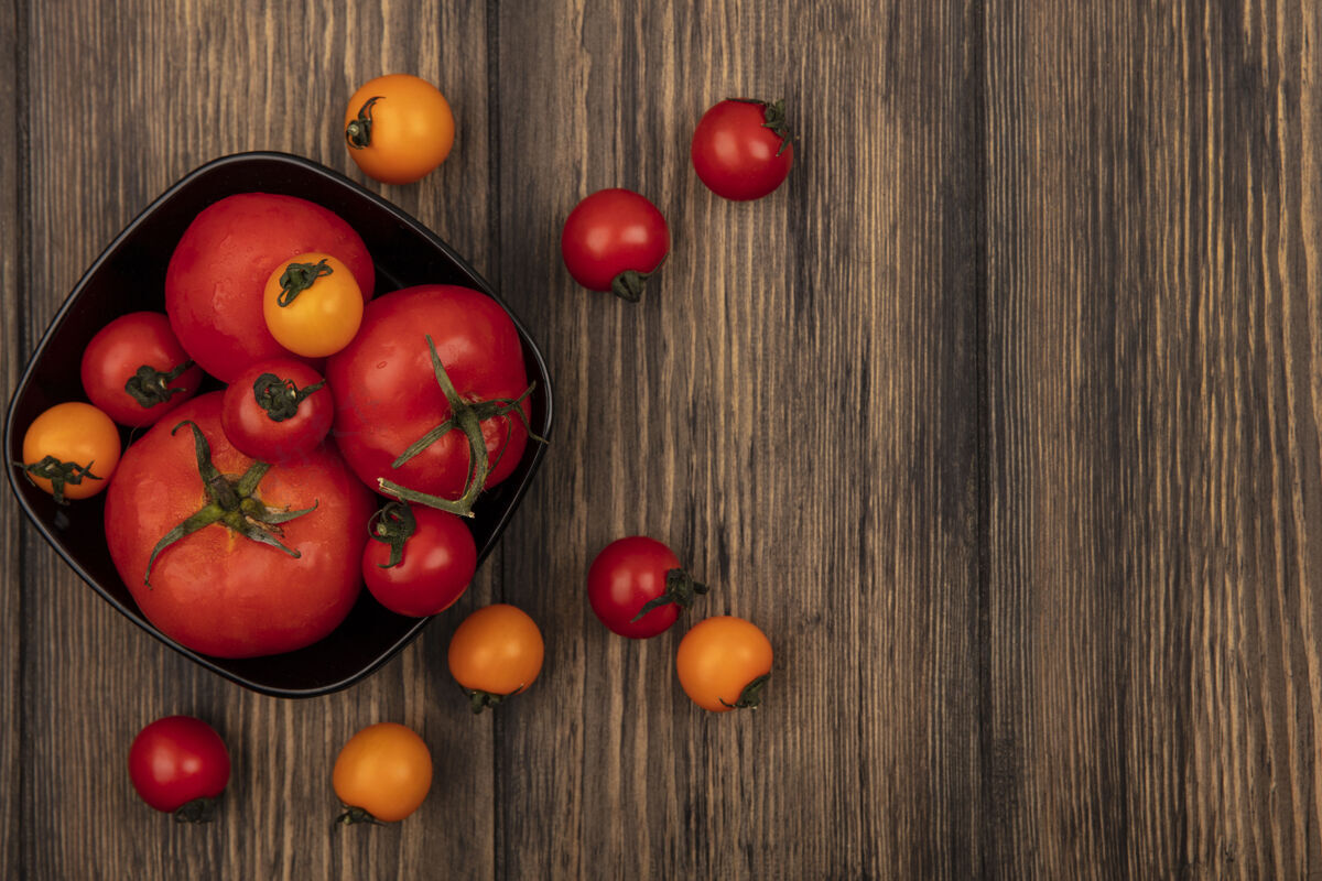 有机大号红色西红柿的顶视图在一个碗上 樱桃西红柿被隔离在一个有复制空间的木墙上新鲜农业蔬菜