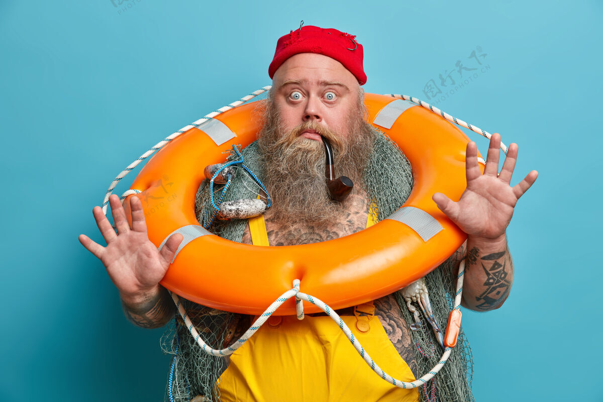 胡须吓坏了的水手举起手掌 瞪着被窃听的眼睛 害怕地笑 摆出橙色充气救生圈 渔网 晕船的姿势海洋姿势体验