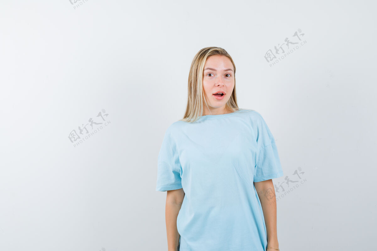 夏天金发女孩站直了 穿着蓝色t恤对着镜头摆姿势 看起来很漂亮 正对着镜头积极假期魅力