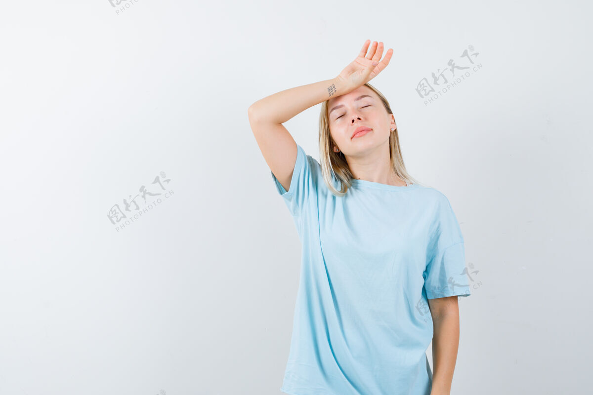 天空金发女孩把手放在额头上 穿着蓝色t恤头痛 看起来很疲惫前视图情绪肖像前面