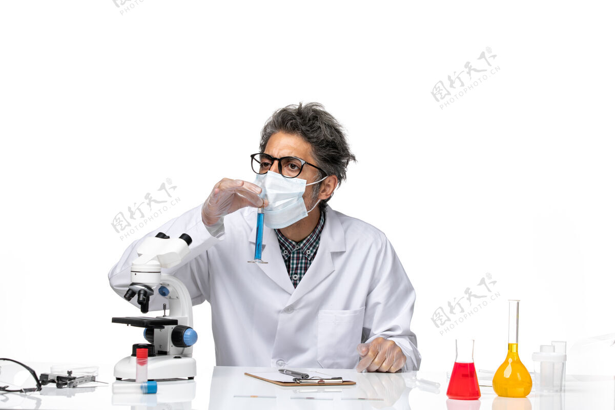 人正面图中年科学家穿着特制的衣服坐着拿着装有溶液的烧瓶实验室外套前面实验室