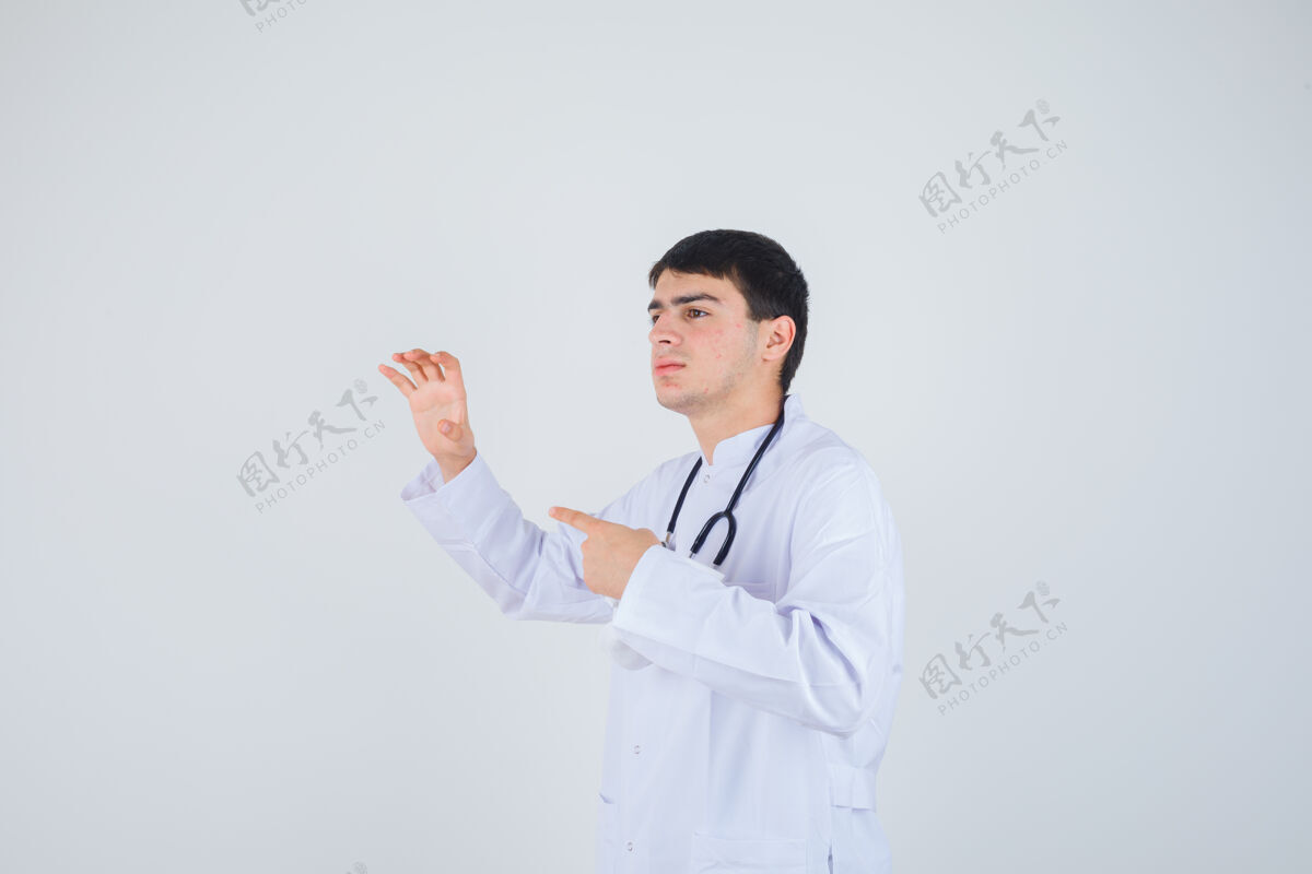 健康年轻人露出爪子的手势 指着左边穿着白色制服 神情开朗 正前方看去制服护理肖像