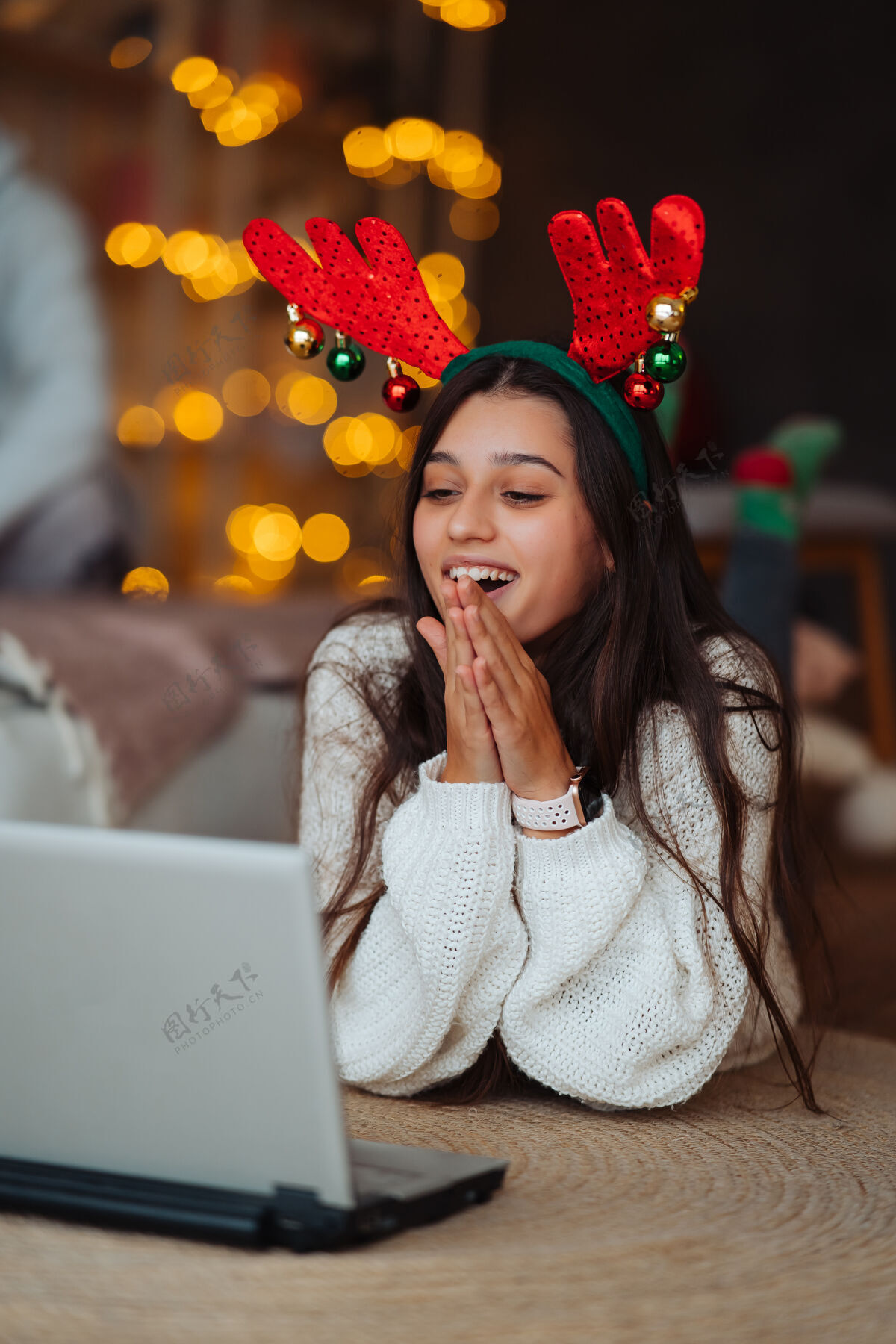 现代在家里庆祝圣诞节期间 一个长着鹿角的女人微笑着用笔记本电脑和网友聊天人礼物互联网