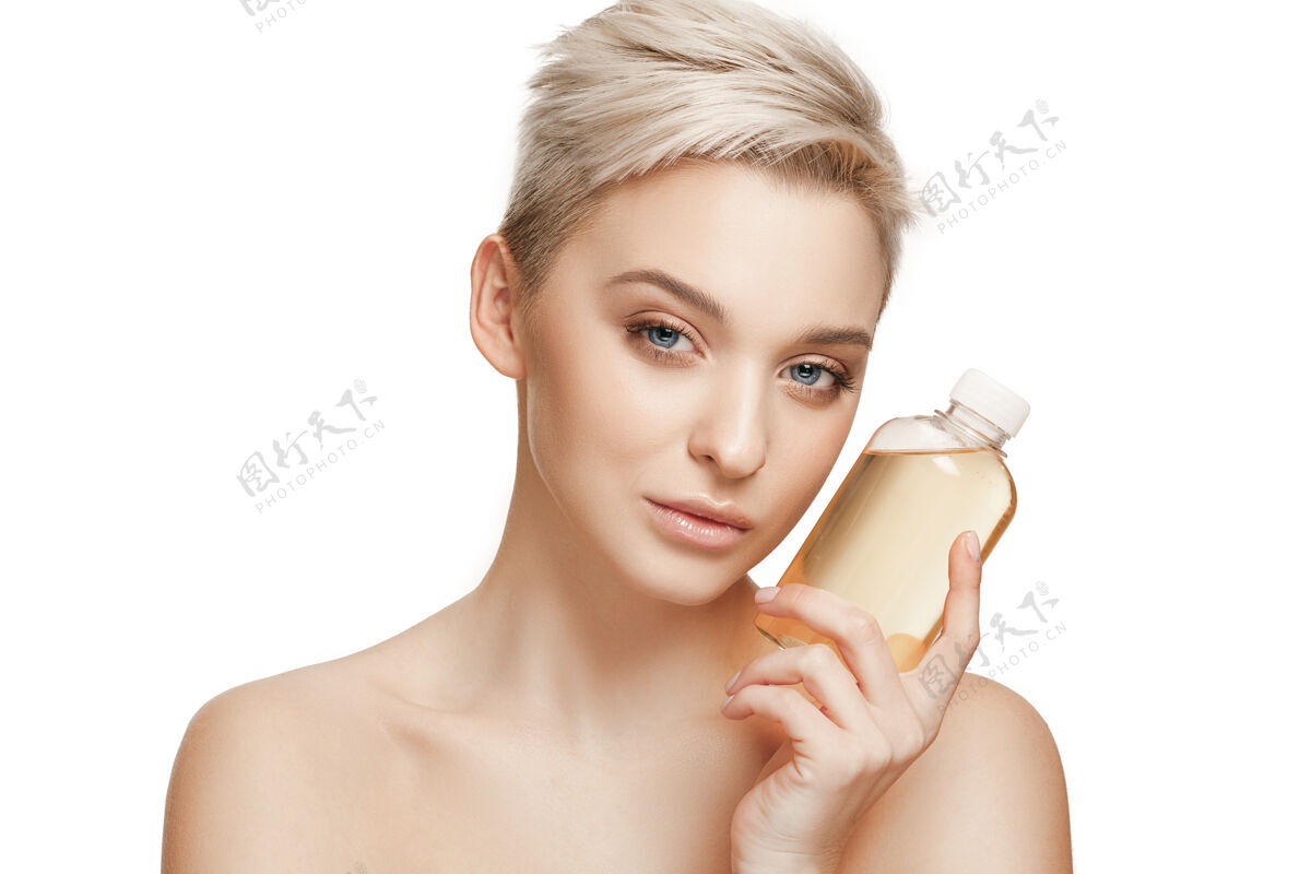 身体美丽的概念拥有完美皮肤的白种人美女拿着油瓶芳香美容爱