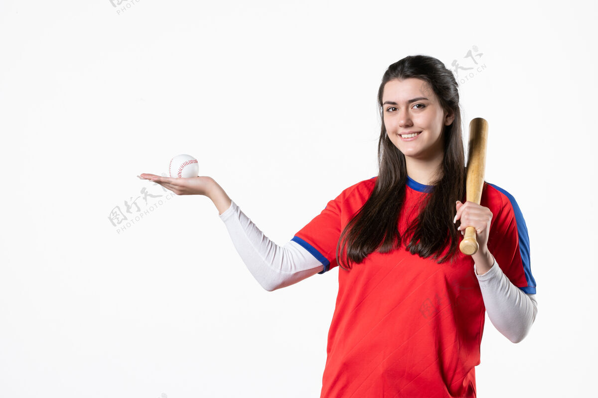 微笑前视图：带球棒和球的女棒球运动员视图人前面