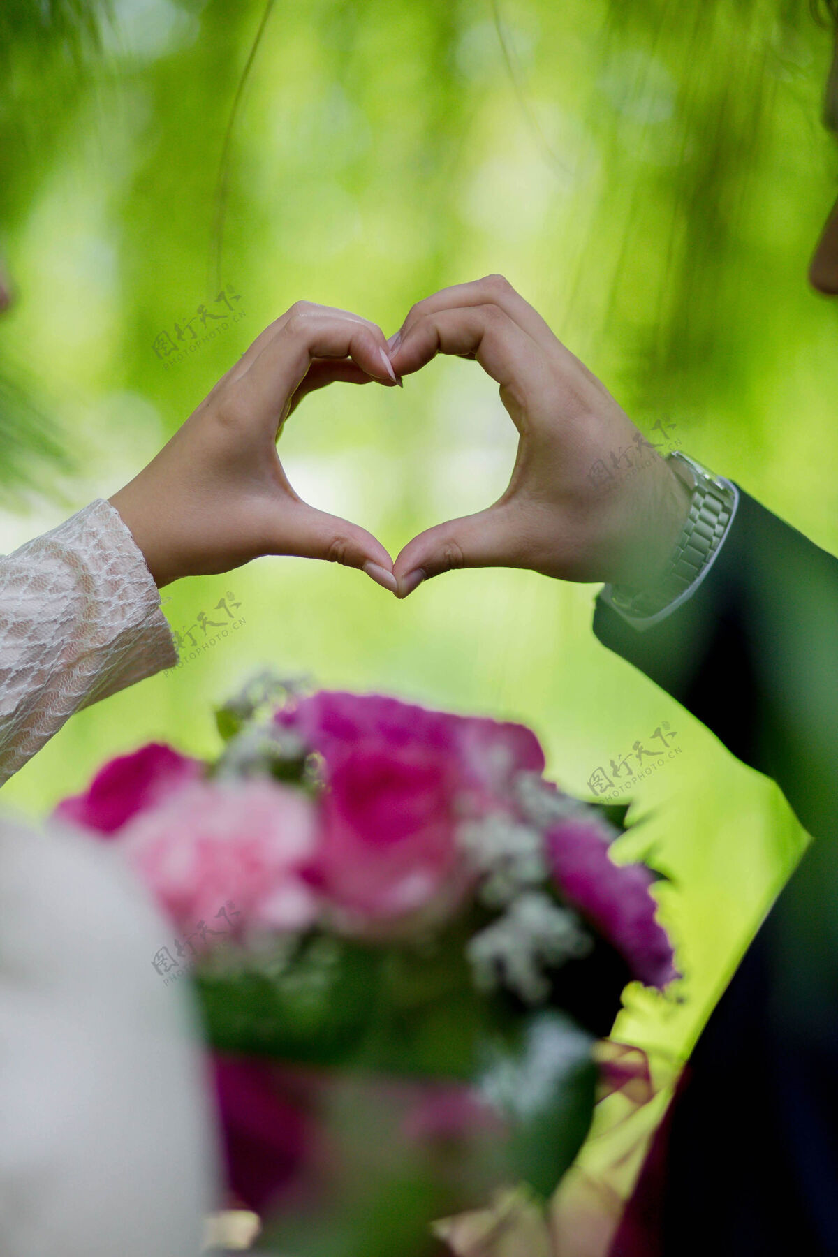 心一个新娘和一个新郎用手抱着一颗心的垂直镜头手垂直情侣
