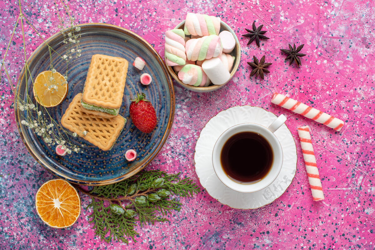 桌子粉红色桌子上的美味华夫饼 一杯茶和棉花糖的俯视图糖华夫饼饼干