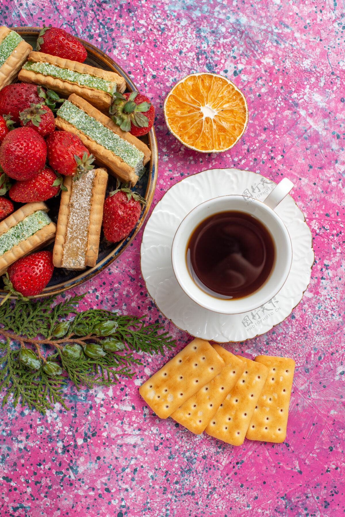 美味俯瞰美味的华夫饼 粉色表面上有一杯茶和新鲜的红色草莓咖啡烘焙热的