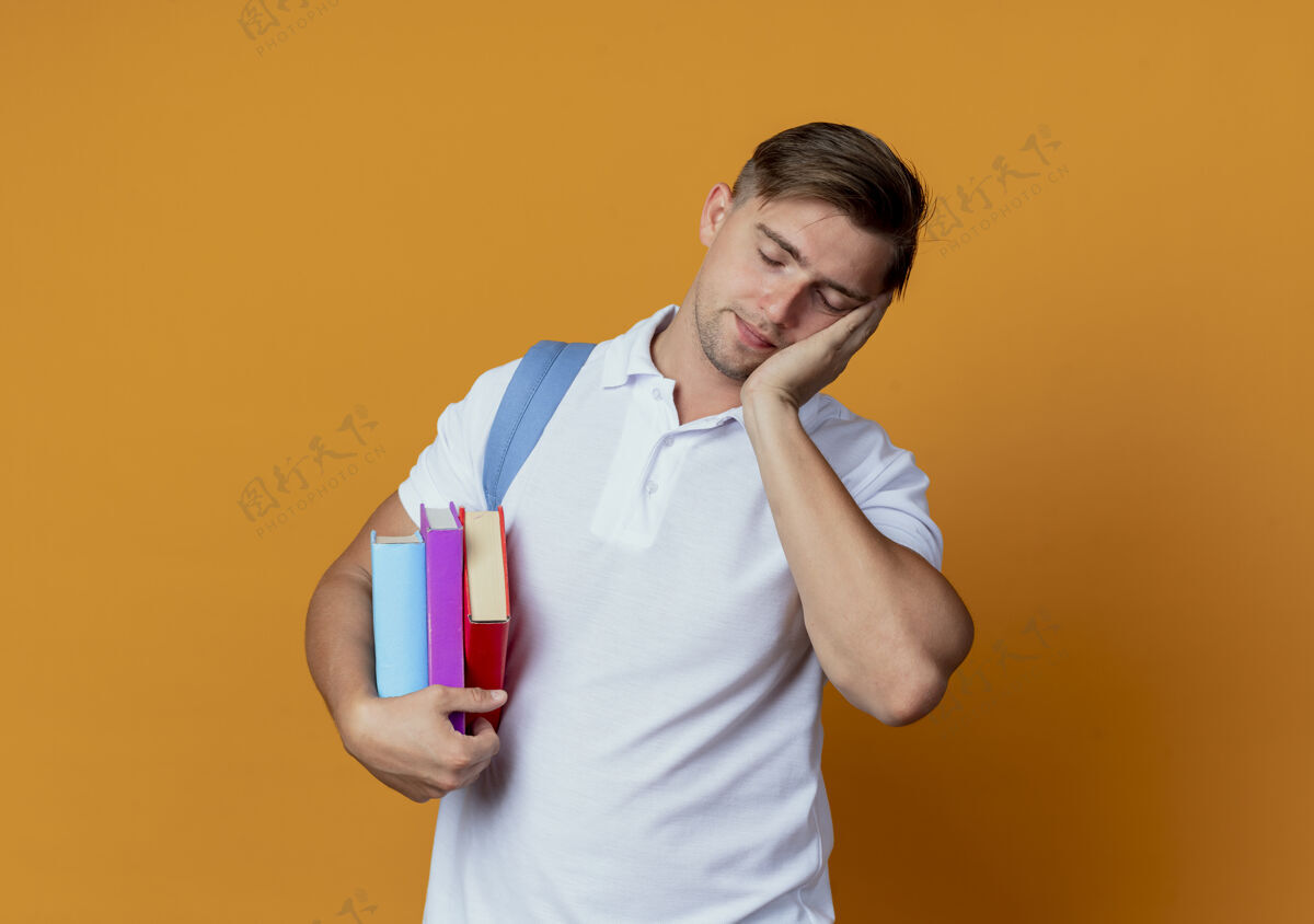 学生闭着眼睛年轻帅气的男生背着书包拿着书橙色包眼睛