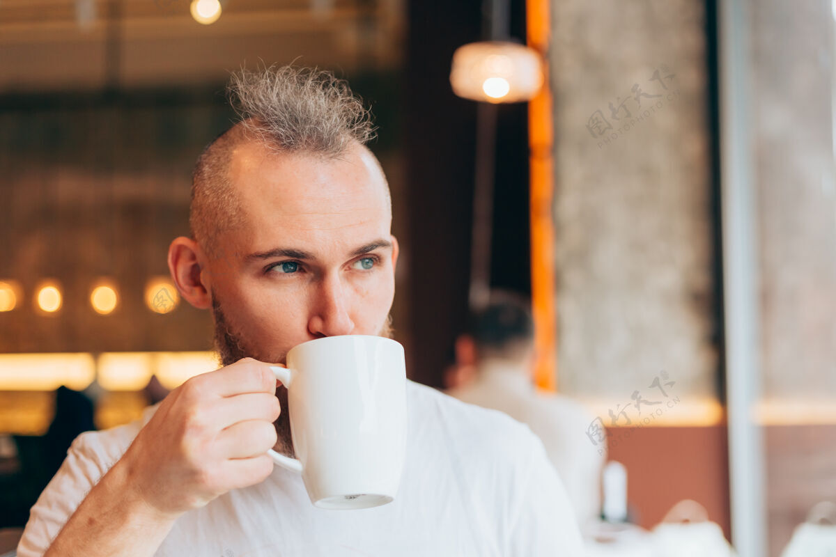 餐厅一个野蛮的欧洲人早上在咖啡馆里喝着一杯热咖啡芳香室内热