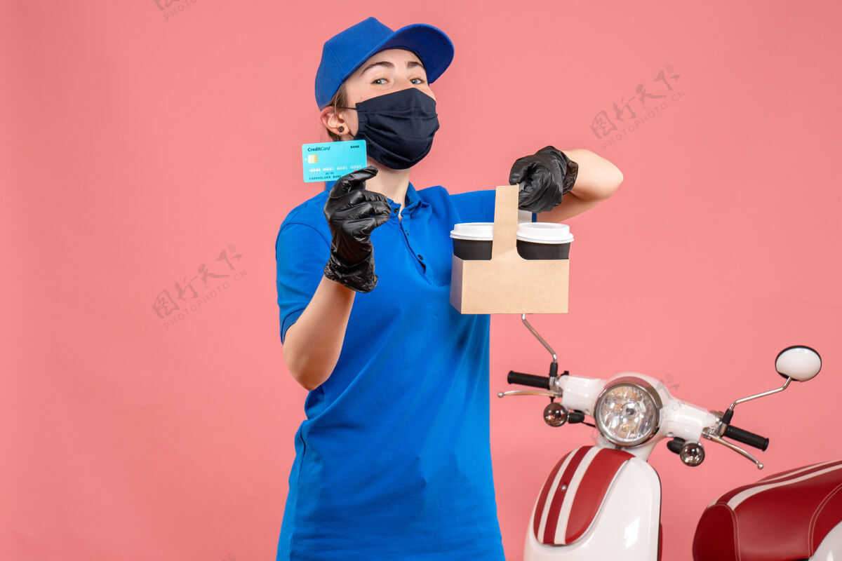 工作正面图：戴着口罩的女快递员 粉色的咖啡和银行卡工人服务送货