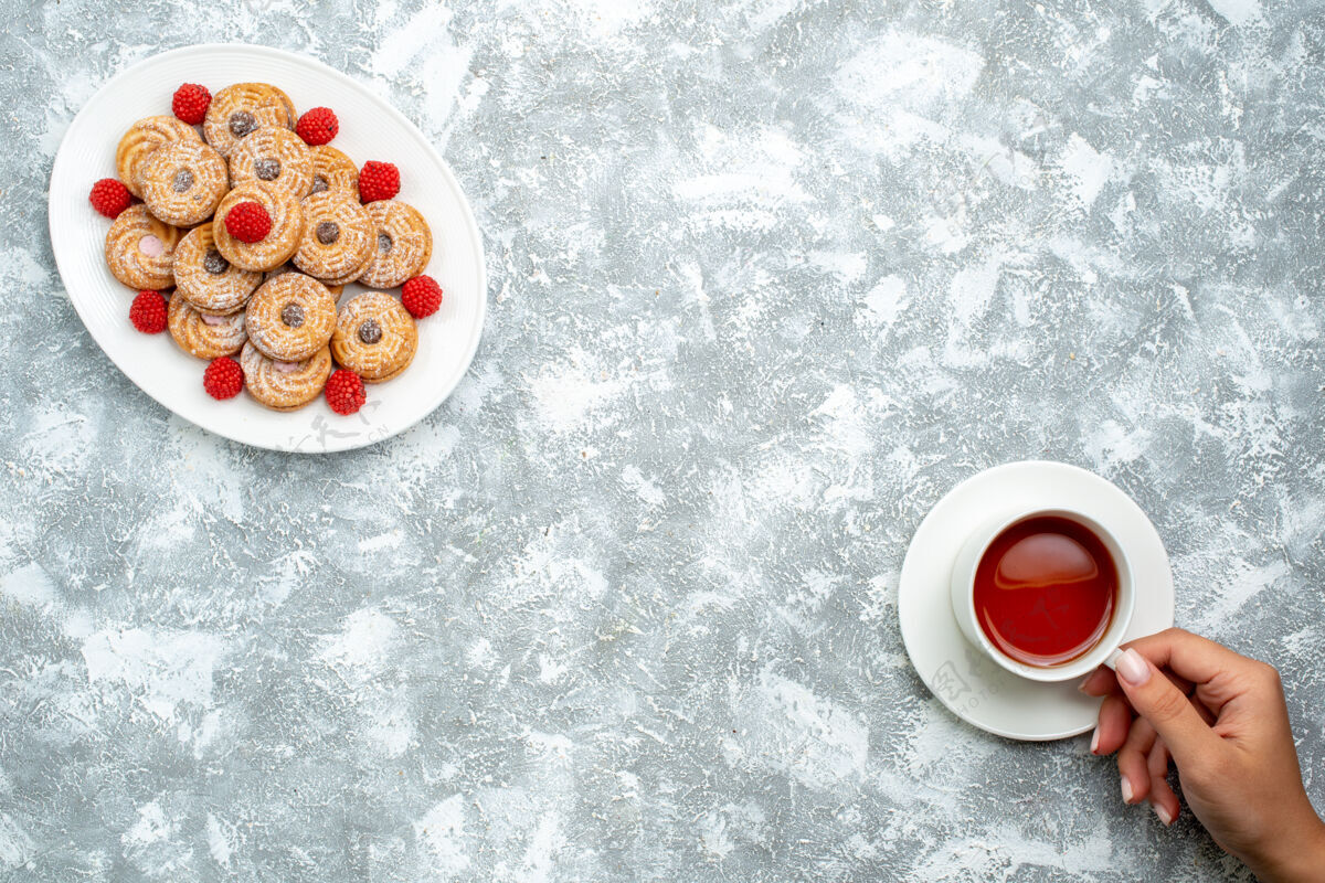 饼干顶视图甜饼干与覆盆子圈内板上的白色背景饼干糖饼干蛋糕茶甜杯子茶潘趣酒