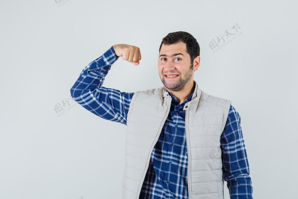 男人身穿衬衫 无袖夹克的年轻人展现手臂肌肉 看上去很自信 前视图肌肉成年人欢呼