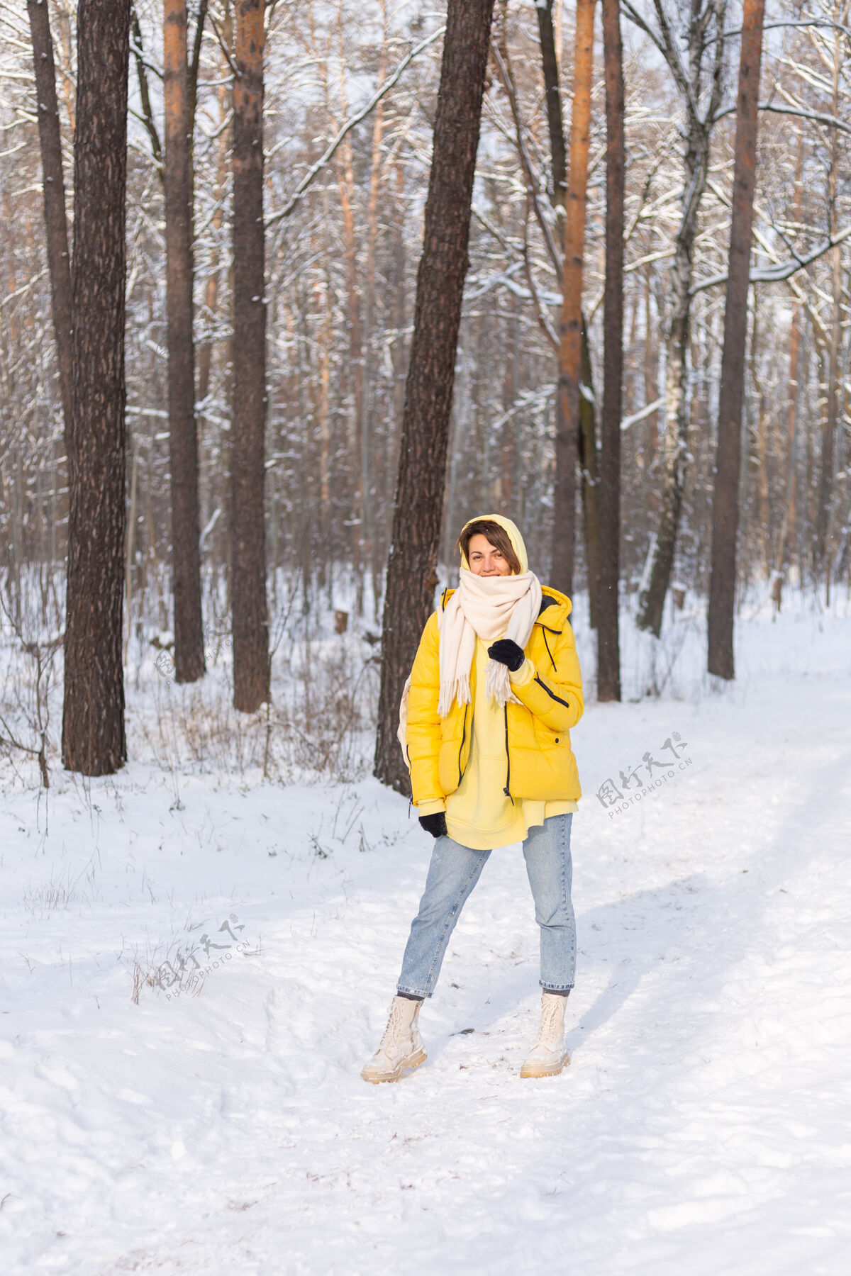 外面美丽的年轻开朗的女人在雪景的冬日森林里玩得很开心 穿着暖和的衣服在冬天和雪里快乐人乐趣季节