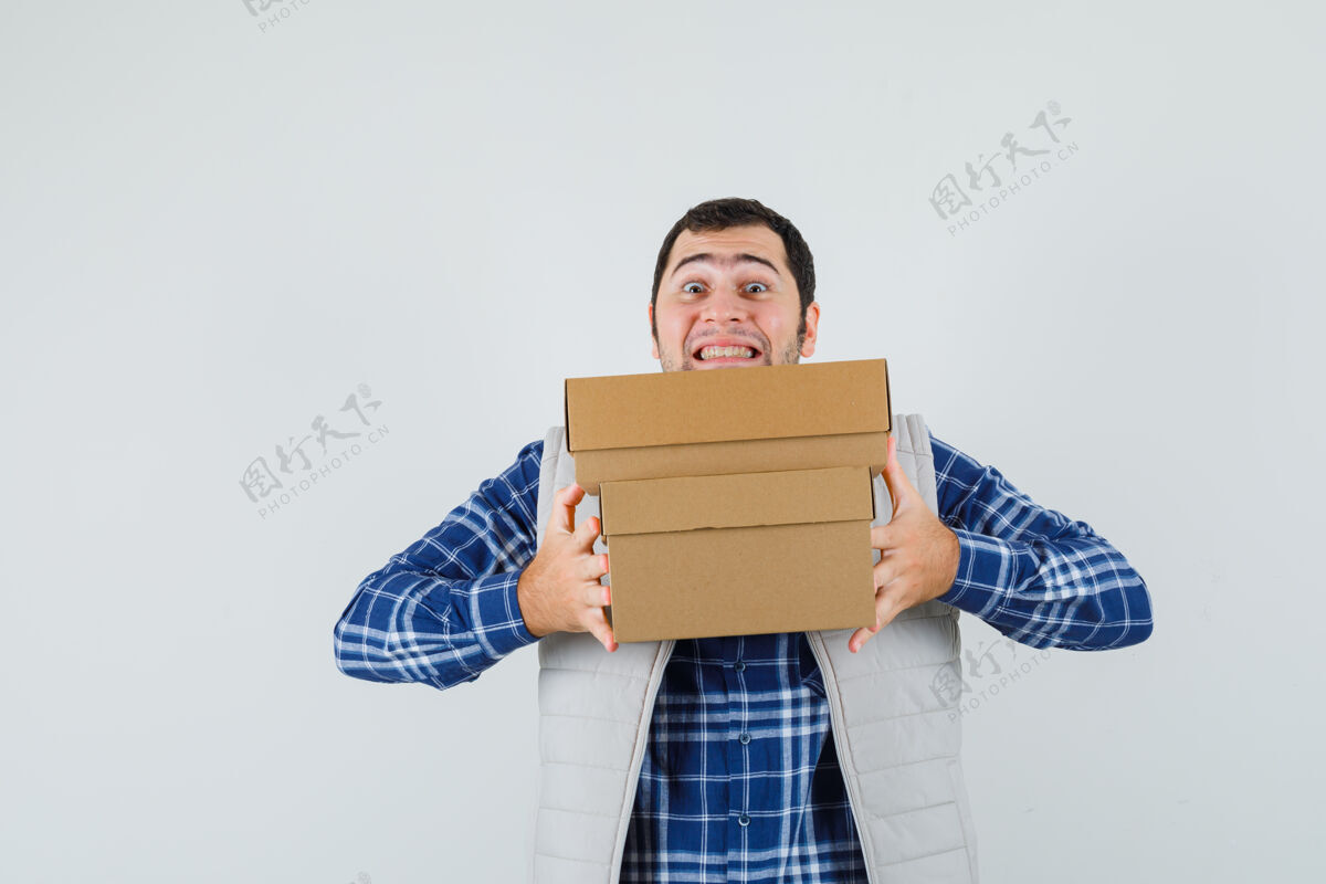 肖像年轻的男人拿着箱子 穿着衬衫 夹克 看上去很快乐 正对着窗外正面休闲男