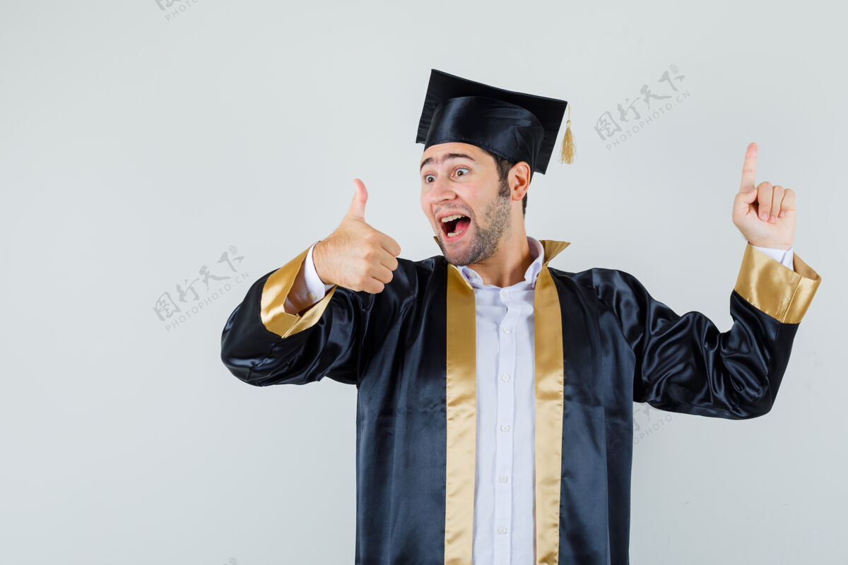 男人年轻人指着我 穿着毕业制服 竖起大拇指 看上去很高兴 正对着我欢呼休闲衬衫