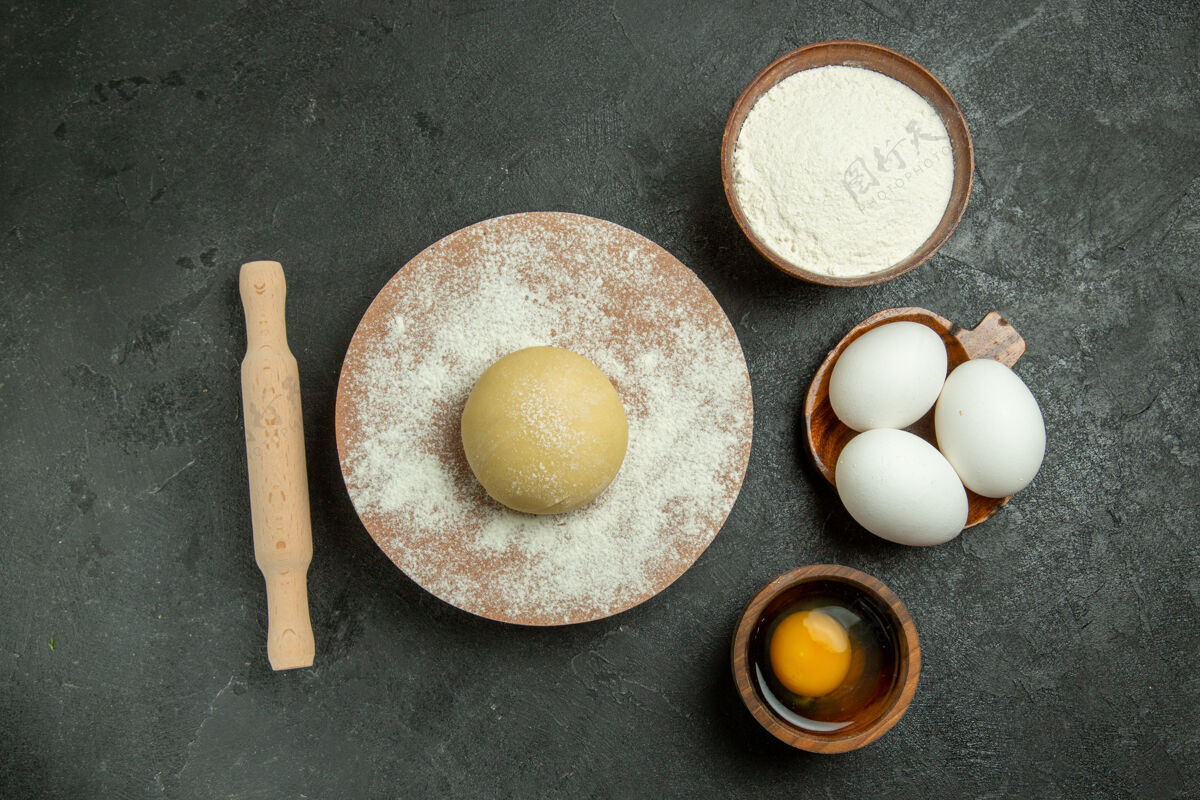 新鲜顶视图生圆形面团与面粉和鸡蛋的灰色背景面粉食品面团生粉膳食健康容器