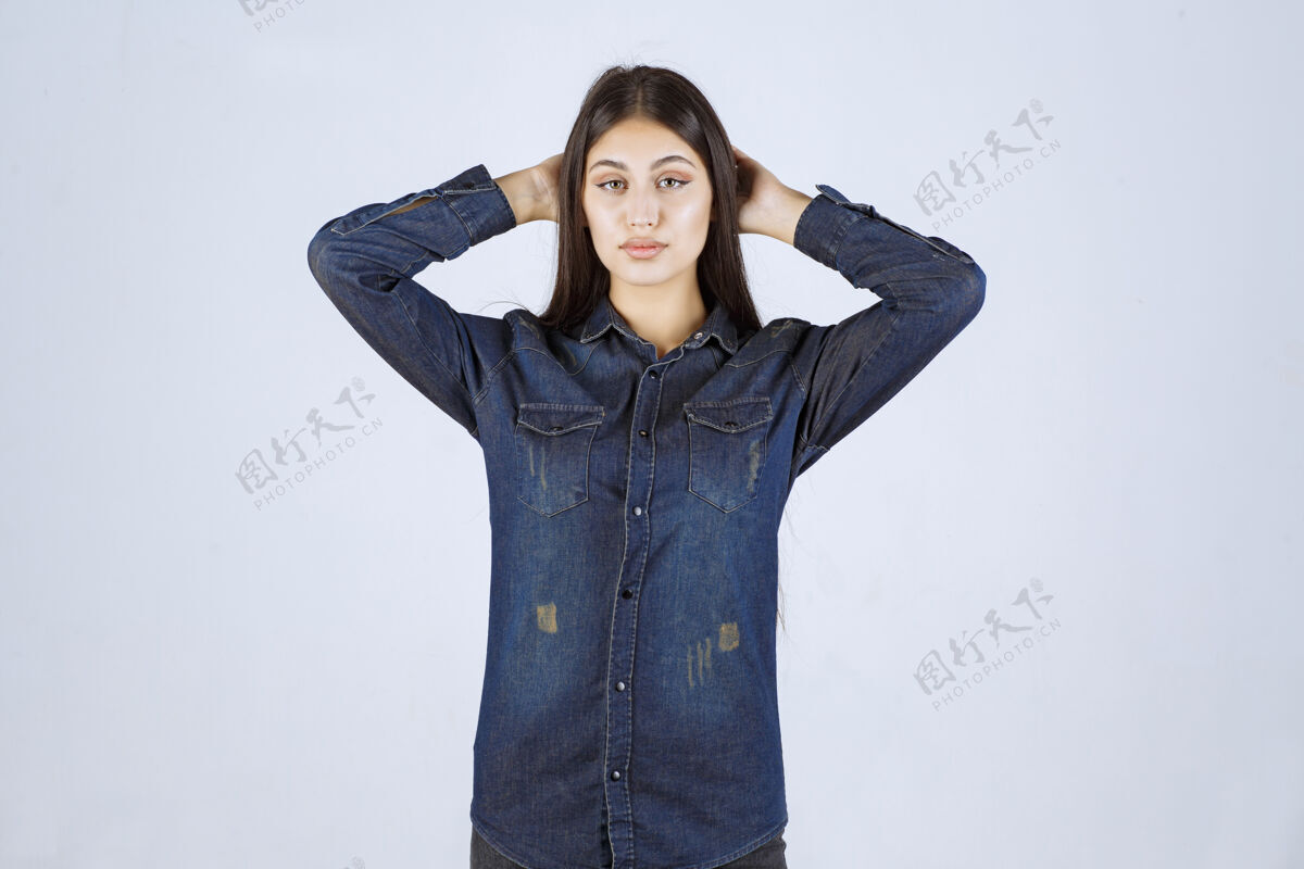 年轻人穿着牛仔衬衫的年轻女子摆出中性诱人的姿势 没有任何反应浪漫呼吁姿势