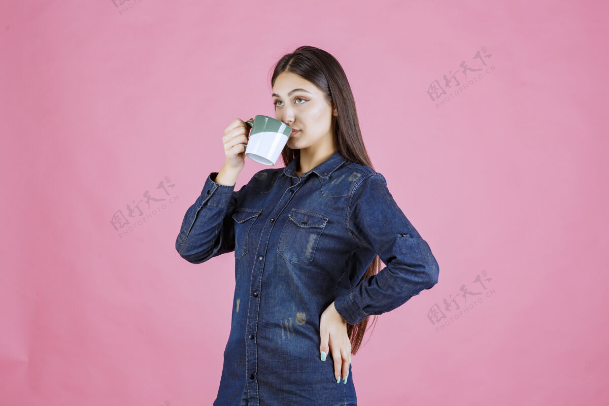 年轻人年轻女子拿着一个白绿色的咖啡杯 闻着商业女性聪明