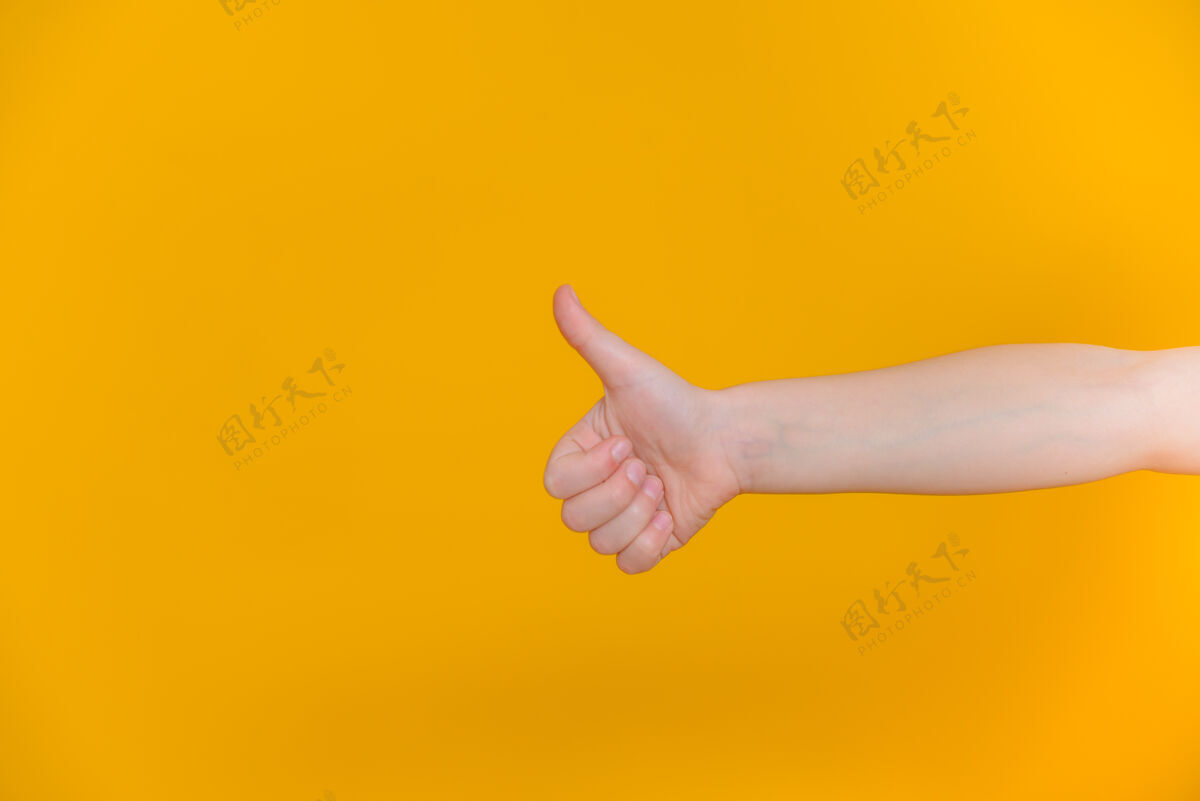 手指孩子们的大拇指向上一个黄色的孤立向上手手臂