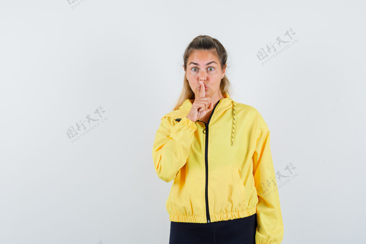 棒球服一个金发女人穿着黄色的棒球服和黑色的裤子表现出沉默的姿态 看起来很严肃手势严肃黑发