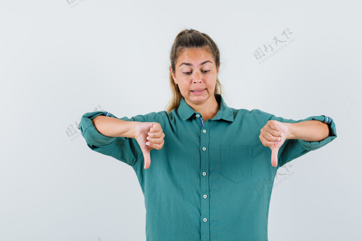 衬衫穿着绿色上衣的年轻女子竖起大拇指 看上去很不高兴女人黑发头发