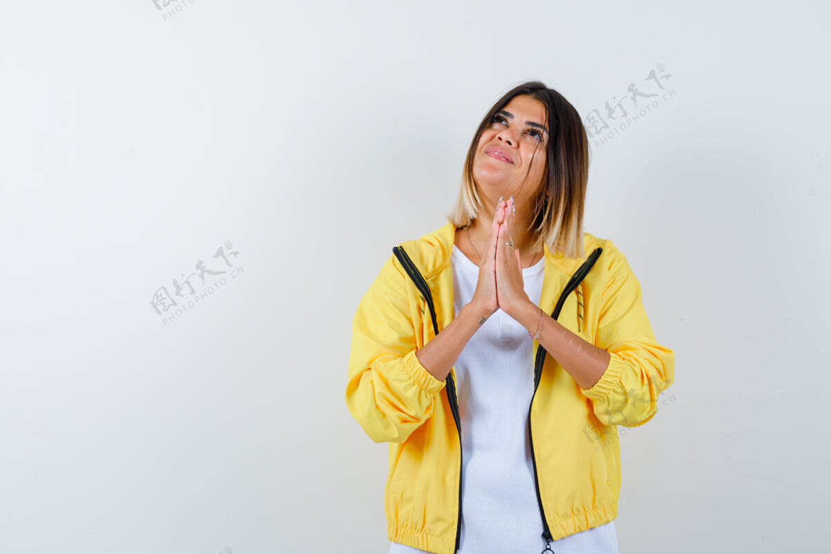 销售身穿白色t恤 黄色夹克 神采奕奕的年轻女孩双手合十祈祷着人夹克成人