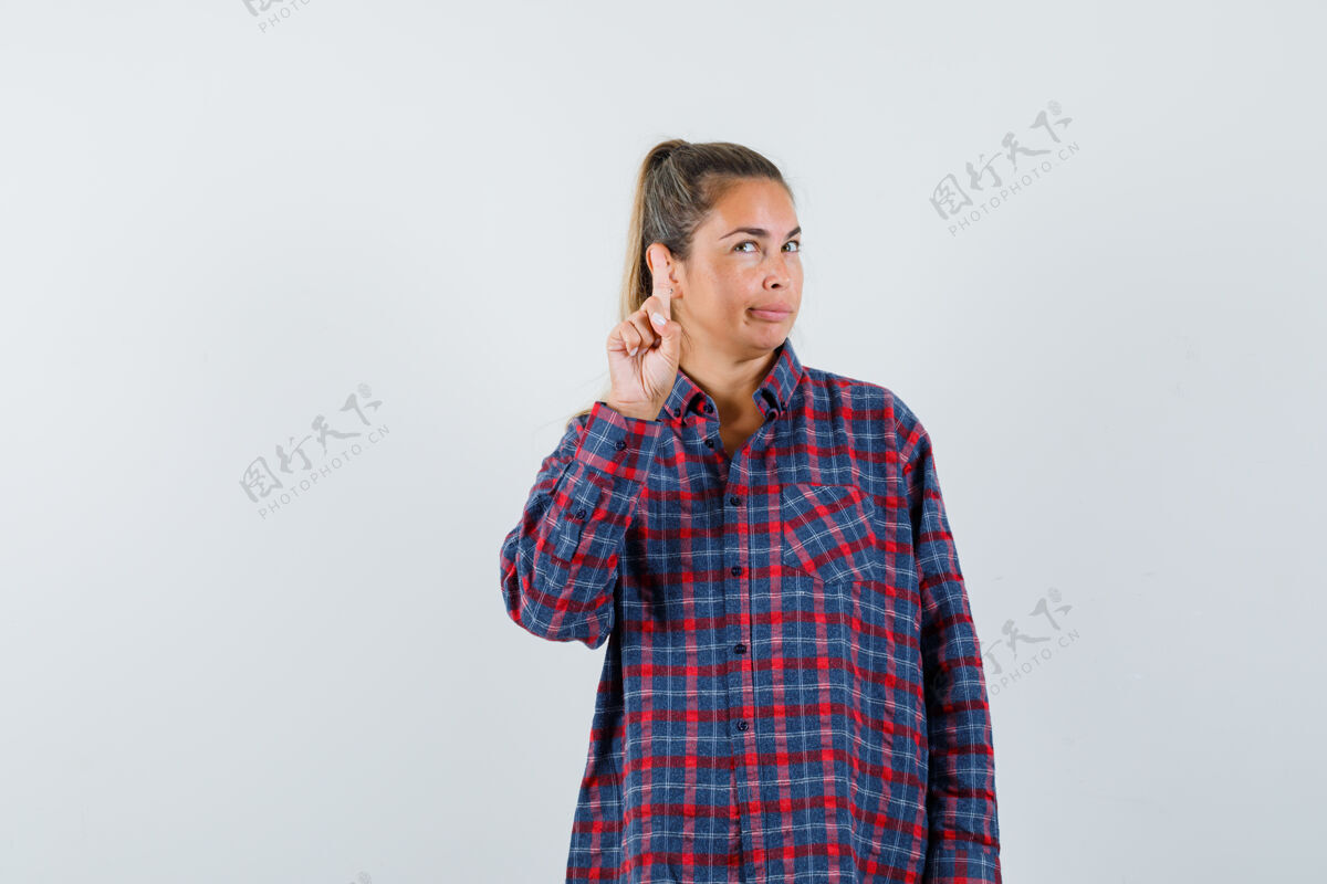 提高穿着格子衬衫的年轻女子举起食指做着尤里卡手势 神情沉思人目录尤里卡