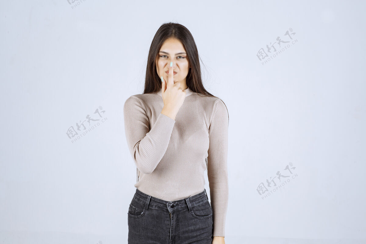 休闲穿灰色衬衫的女孩指着她的嘴姿势年轻人类